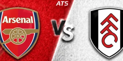 Wide horizontal match preview banner showing Arsenal vs Fulham, split diagonally with contrasting red and light gray textured backgrounds. Arsenal’s crest is on the left, Fulham’s black-and-white shield logo on the right, with a glowing “VS” in the center and “ATS” text at the top.