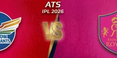 A horizontal sports match-up banner for the IPL 2026 season. The left side has a deep red textured background featuring the Lucknow Super Giants logo (a blue circular badge with multicolored wings and a cricket bat). The right side has a vibrant pink textured background featuring the Rajasthan Royals logo (a pink shield with two gold lions and a crown). The two sides are separated by a diagonal gold divider in the center, with a large 3D gold 