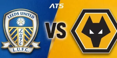 This wide-format sports graphic depicts a match-up between Leeds United and Wolverhampton Wanderers (Wolves). The image is split diagonally down the center: the left side features a textured blue background housing the official Leeds United crest, while the right side features a textured gold background with the black-and-gold geometric Wolves wolf-head logo. In the center, a bold, stylized 