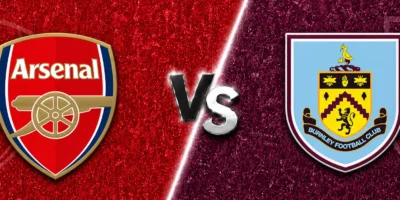 Arsenal vs Burnley match banner with both club crests on split red and claret textured backgrounds, separated by a glowing diagonal line and a metallic VS graphic in the center.