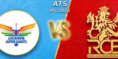 IPL 2026 promotional match graphic featuring Lucknow Super Giants versus Royal Challengers Bengaluru. The design uses a split background with light blue on the left for LSG and bright red on the right for RCB, divided diagonally by a gold stripe. A large circular Lucknow Super Giants logo appears on the left, while the gold RCB lion crest dominates the right side. A glowing gold “VS” sits in the center with “ATS IPL 2026” text above it. Small star icons appear in the top corners, and the textured background gives the image a bold, energetic sports-poster look.