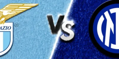 A wide sports matchup graphic featuring Lazio and Inter facing off. Lazio’s crest appears on the left over a textured sky-blue background with a faint oversized club watermark in the backdrop, while Inter’s circular blue-and-black crest is displayed on the right over a deep blue textured background with faded club branding. A glowing diagonal divider separates the two sides, with large metallic “VS” lettering centered between the clubs. The design uses dramatic lighting, textured patterns, and soft gray borders above and below for a polished promotional match graphic.