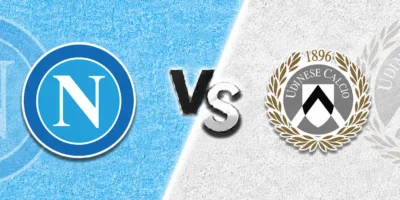 Napoli vs Udinese match prediction banner with the Napoli crest on a light blue textured background and the Udinese crest on a clean white textured background, separated by a bold central “VS” graphic.